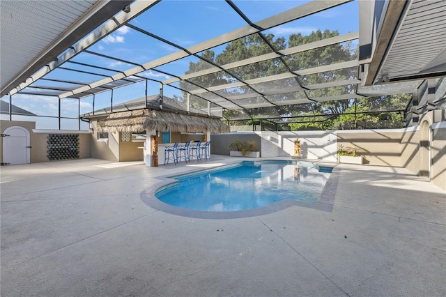 view of swimming pool with a lanai, exterior bar, and a patio