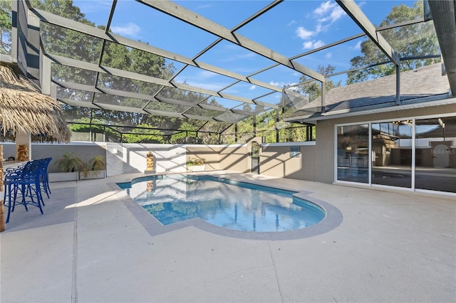 view of pool with glass enclosure and a patio area