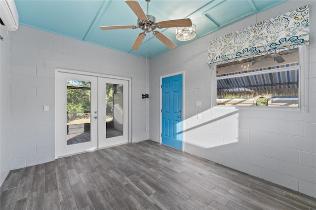 spare room featuring ceiling fan, french doors, wood-type flooring, and a wall mounted air conditioner