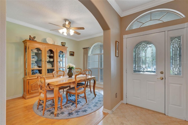 entryway featuring ceiling fan, light hardwood / wood-style flooring, a textured ceiling, and ornamental molding