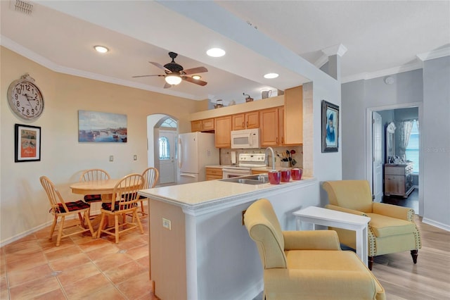 kitchen with kitchen peninsula, decorative backsplash, white appliances, and crown molding