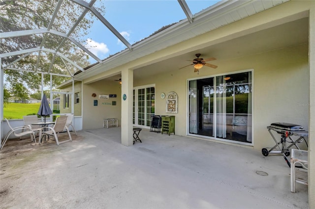 view of patio with glass enclosure and ceiling fan