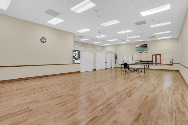 exercise area featuring a drop ceiling and light hardwood / wood-style floors