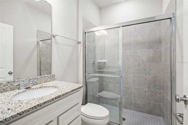 bathroom with vanity, toilet, and a shower with shower door