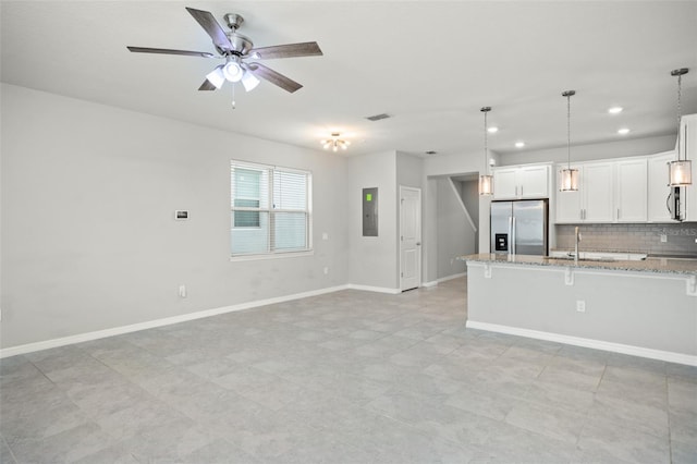 kitchen with decorative light fixtures, white cabinetry, light stone counters, and stainless steel fridge with ice dispenser