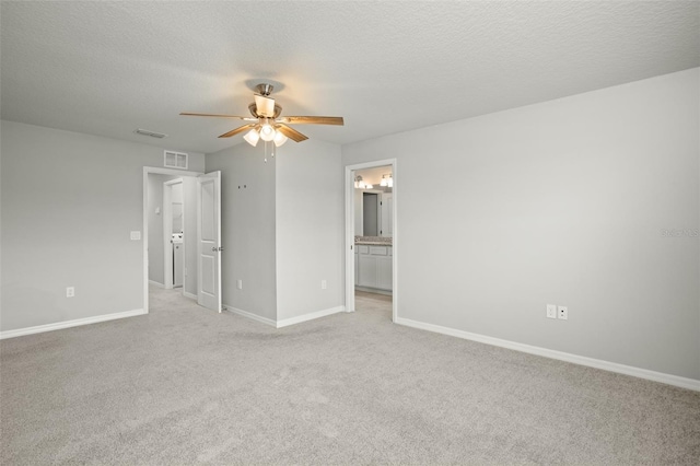 carpeted empty room with ceiling fan and a textured ceiling