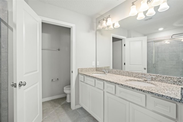 bathroom featuring tile patterned flooring, a textured ceiling, an enclosed shower, toilet, and vanity