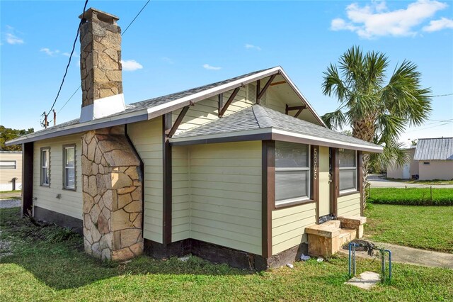5305 S Ridgewood Ave, Port Orange, FL 32127 - view of property exterior with a chimney, a lawn, and roof with shingles