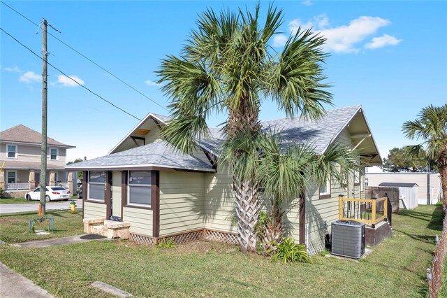 5305 S Ridgewood Ave, Port Orange, FL 32127 - view of property exterior with a yard, central AC, and roof with shingles