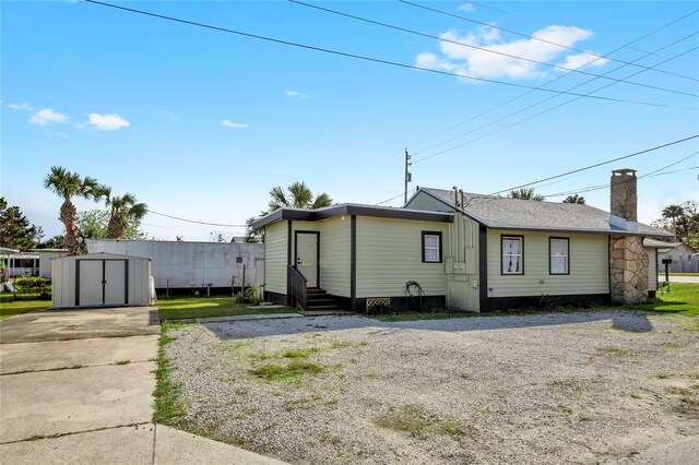 5305 S Ridgewood Ave, Port Orange, FL 32127 - back of property with concrete driveway, entry steps, and a chimney