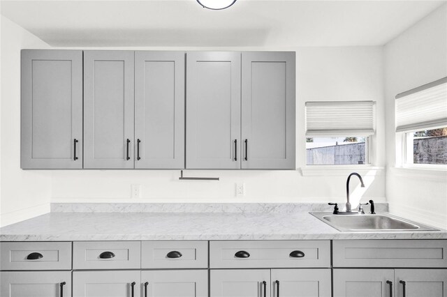 5305 S Ridgewood Ave, Port Orange, FL 32127 - kitchen featuring gray cabinets, a sink, and light stone counters