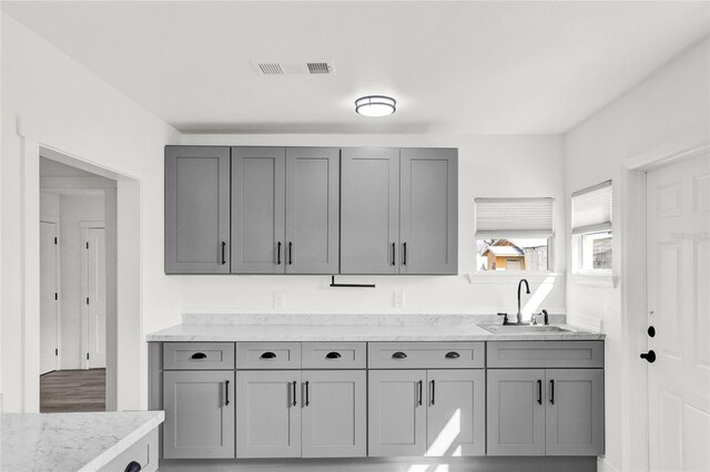 5305 S Ridgewood Ave, Port Orange, FL 32127 - kitchen with a sink, gray cabinets, and light stone countertops