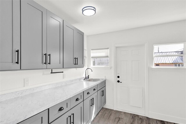 5305 S Ridgewood Ave, Port Orange, FL 32127 - kitchen featuring a sink, gray cabinetry, light wood-type flooring, and light stone countertops