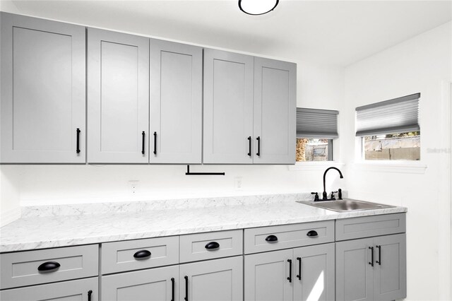 5305 S Ridgewood Ave, Port Orange, FL 32127 - kitchen with gray cabinetry, a sink, and light stone countertops