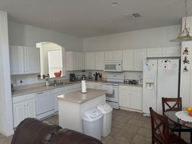 kitchen featuring white cabinets, a kitchen island, pendant lighting, and white appliances