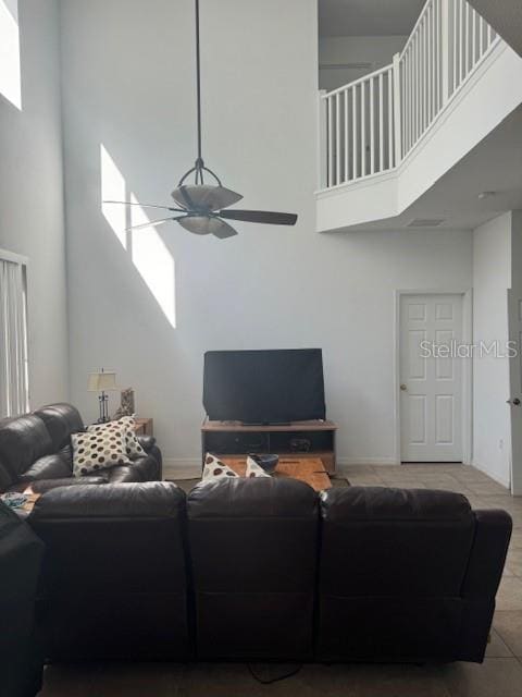 living room with ceiling fan and a high ceiling