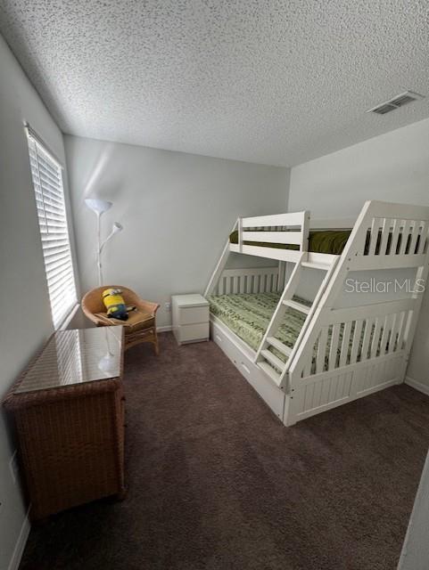 carpeted bedroom with a textured ceiling