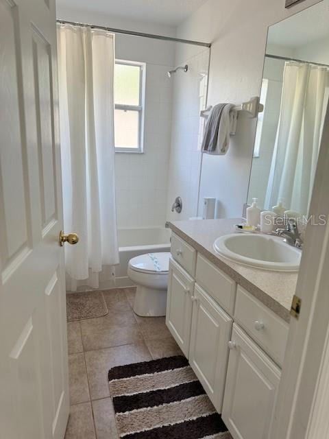 full bathroom featuring tile patterned flooring, vanity, toilet, and shower / bath combo with shower curtain