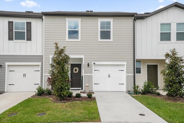 townhome / multi-family property featuring a garage and a front lawn