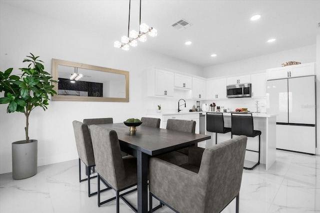 dining area with ceiling fan and sink