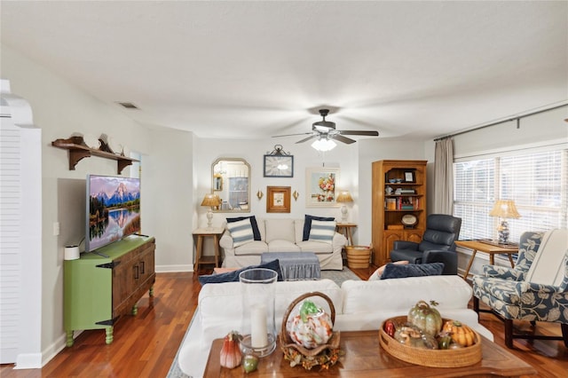 living room featuring ceiling fan and dark wood-type flooring