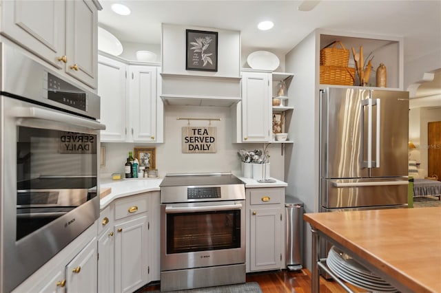 kitchen featuring white cabinets, appliances with stainless steel finishes, and dark wood-type flooring