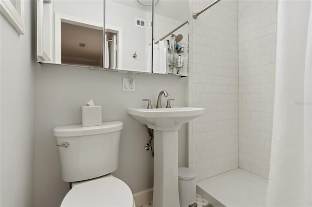 bathroom featuring toilet and walk in shower