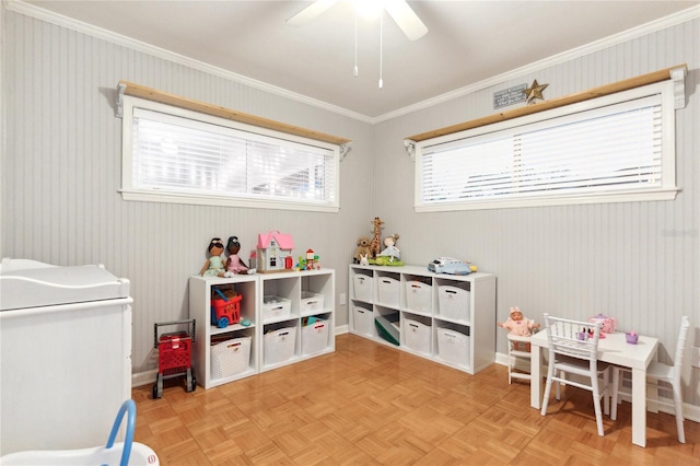 recreation room with light parquet flooring, ceiling fan, and crown molding