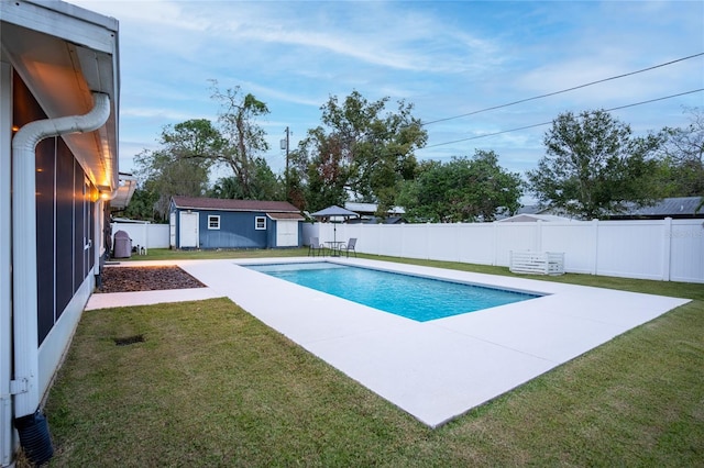 view of pool with a patio, an outdoor structure, and a lawn