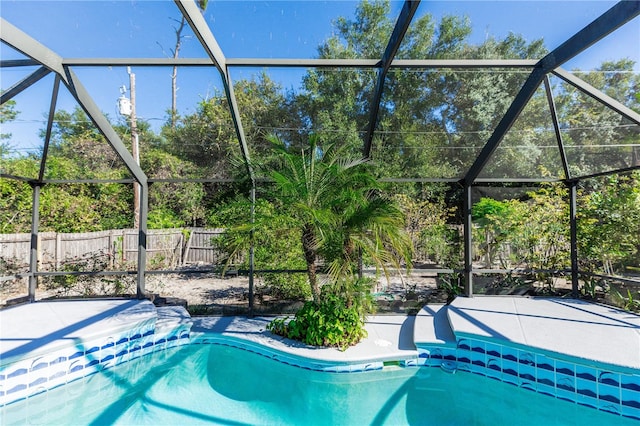 view of swimming pool featuring a lanai