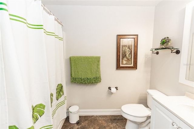 bathroom featuring baseboards, vanity, and toilet