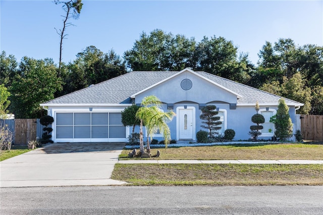 ranch-style house featuring stucco siding, a shingled roof, fence, a garage, and driveway