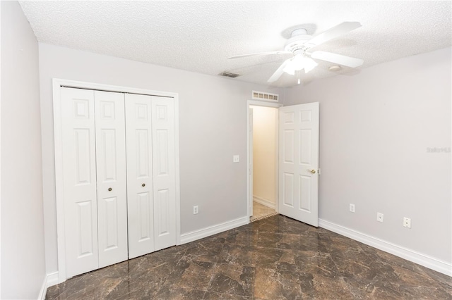 unfurnished bedroom with visible vents, a textured ceiling, and baseboards