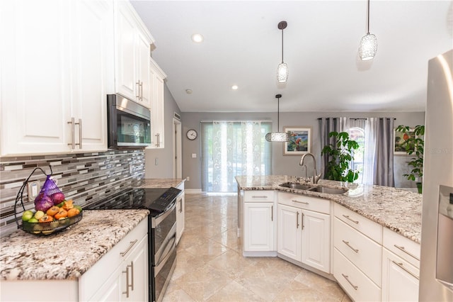 kitchen featuring stainless steel appliances, hanging light fixtures, a sink, and white cabinetry