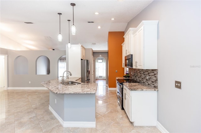 kitchen featuring a sink, white cabinetry, appliances with stainless steel finishes, an island with sink, and decorative light fixtures