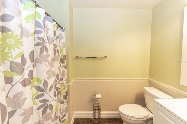 bathroom with baseboards, vanity, and toilet