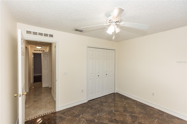 unfurnished bedroom featuring a closet, visible vents, a textured ceiling, and baseboards