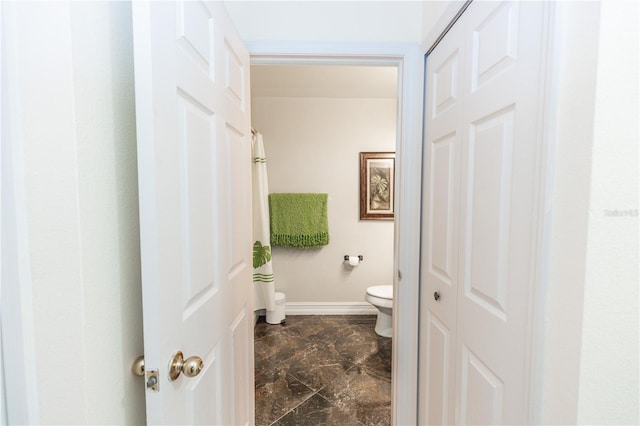 bathroom featuring toilet and baseboards