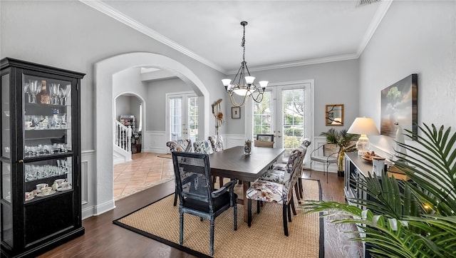 dining area featuring dark hardwood / wood-style flooring, an inviting chandelier, and ornamental molding