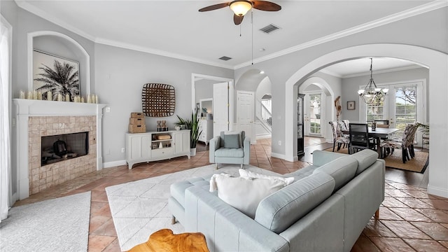 living room featuring a fireplace, ceiling fan with notable chandelier, and ornamental molding