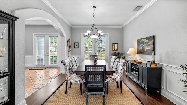 dining space with french doors, ornamental molding, and dark wood-type flooring