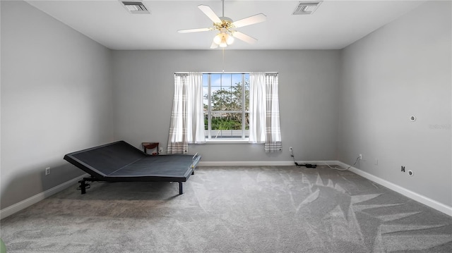 unfurnished room with ceiling fan and carpet