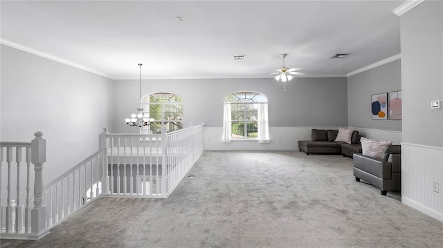 carpeted living room with ceiling fan with notable chandelier and ornamental molding