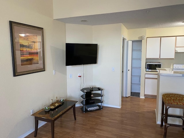 living room featuring dark wood-type flooring and a textured ceiling