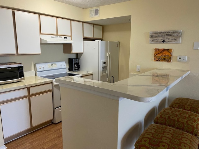 kitchen with kitchen peninsula, electric stove, white cabinets, light hardwood / wood-style floors, and white fridge with ice dispenser