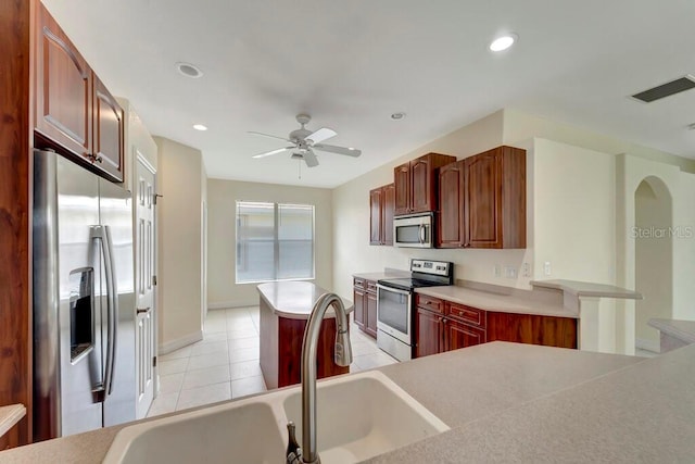 kitchen featuring light tile patterned floors, stainless steel appliances, ceiling fan, and sink