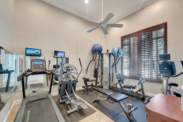 exercise room featuring a high ceiling, ceiling fan, and crown molding