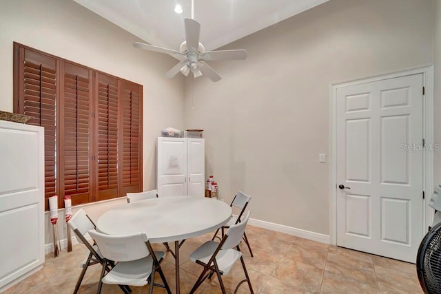 dining room with ceiling fan, light tile patterned floors, and vaulted ceiling