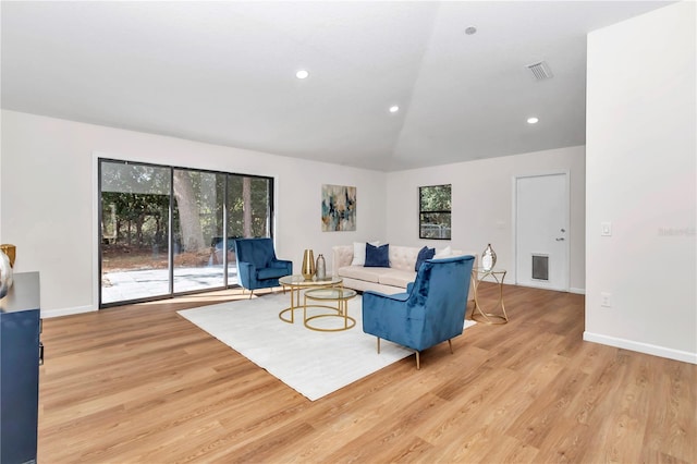 living room with light hardwood / wood-style flooring and lofted ceiling