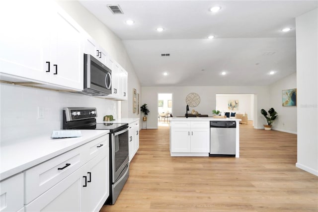 kitchen with white cabinetry, stainless steel appliances, light hardwood / wood-style flooring, backsplash, and lofted ceiling